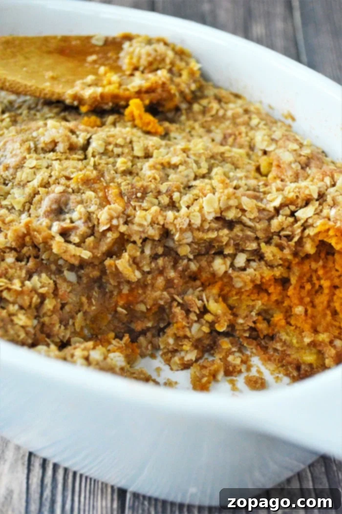 Homemade Pumpkin Crisp with Oat Crumble Baked sweet pumpkin crisp casserole with oat crumble topping in a white dish, reminiscent of a pumpkin crisp without cake mix.