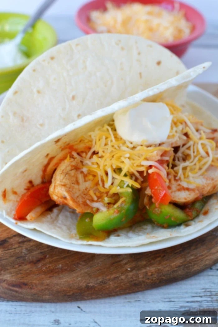 One Pot Wonder Chicken Fajitas 2 Close-up of vibrant crockpot chicken fajitas with tender shredded chicken, sliced bell peppers, and onions, ready to be served in warm tortillas.