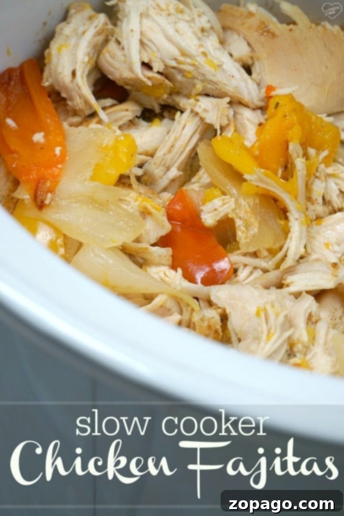 One Pot Wonder Chicken Fajitas 7 Large platter of shredded crockpot chicken fajitas with plenty of bell peppers and onions, garnished with fresh cilantro and lime wedges, ready for serving.
