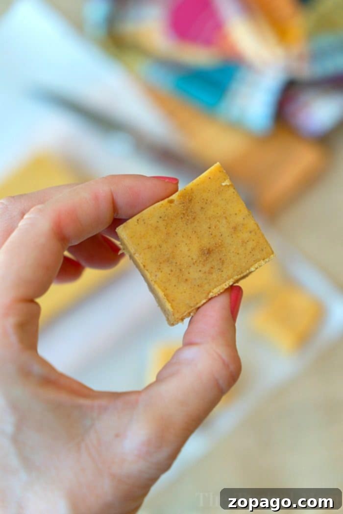 Microwave pumpkin fudge recipe that requires no boiling and tastes delicious! So easy to make and tastes just like a bite of pumpkin pie fudge for the Fall! #pumpkin #fudge #easy #microwave Microwave pumpkin fudge squares on a wooden board.