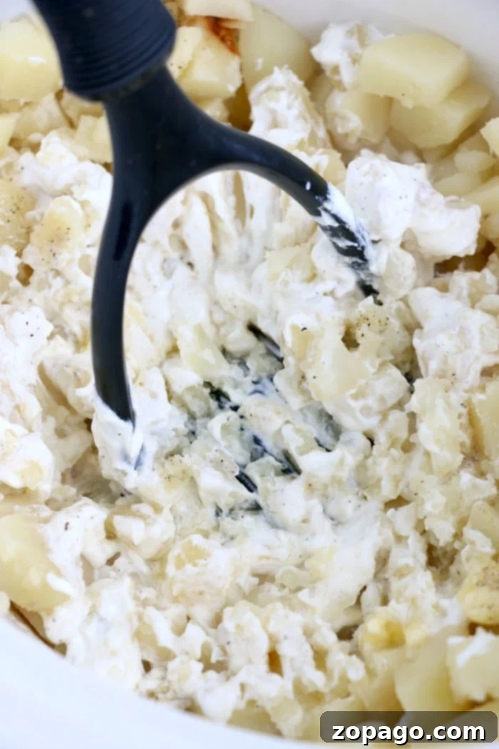 Easy Crockpot mashed potatoes are the perfect side dish served year round and during the holidays. Fluffy and buttery made in your Crockpot and kept warm. #mashedpotatoes #slowcookerpotatoes #crockpotpotatoes #potatoes #crockpotrecipes Slow cooker mashed potatoes, fluffy and buttery