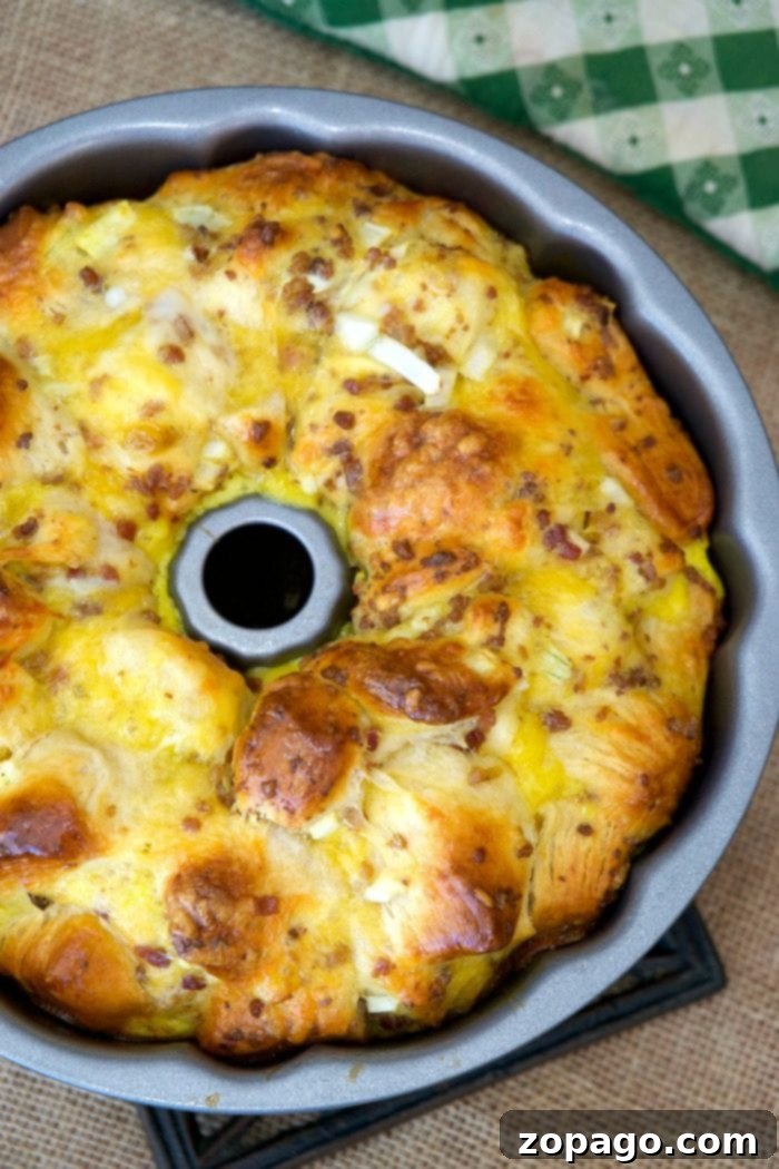 This savory breakfast bundt cake combines bacon, egg, and cheese with biscuits for an unforgettable brunch item. A slice of Bacon, Egg, and Cheese Breakfast Bundt Cake, showcasing the layers of biscuit, egg, bacon, and melted cheese, perfect for a hearty breakfast.