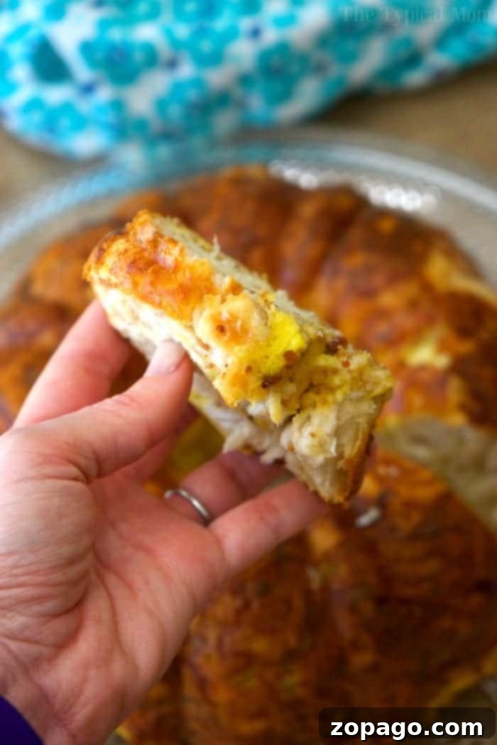 Hearty and delicious breakfast bundt cake, a perfect blend of bacon, egg, cheese, and fluffy biscuits. A festive breakfast bundt cake with bacon, egg, and cheese, garnished with fresh chives, ready to be served for a special occasion.