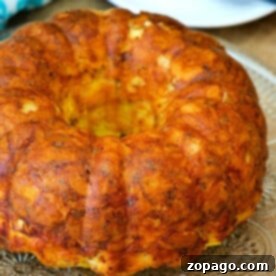 Sunrise Bundt Cake 2 A golden brown breakfast bundt cake sits elegantly on a glass platter, with a knife poised nearby.