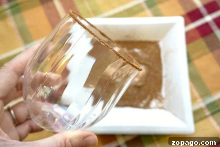 Chilled sparkling apple cider recipe that tastes amazing!! Make it a mocktail or a cocktail, perfect Fall drink that everyone raves about!! #apple #cider #mocktail #cocktail #chilled #drink #fall #sparkling A pitcher of sparkling apple cider surrounded by glasses, apples, and cinnamon sticks, set against a rustic background.