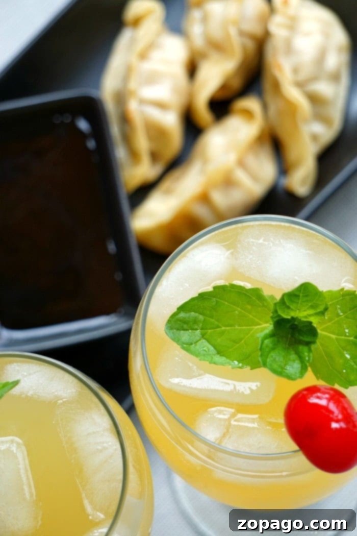 Sparkling Island cocktail is what to call this favorite pineapple drink of mine! Goes perfectly with any meal really and easy to create with rum and pineapple juice. Cocktail or mocktail directions. #pineapple #cocktail #drink #mocktail #punch A beautifully presented glass of pineapple cocktail, adorned with a fresh pineapple wedge and mint, sits on a rustic wooden surface, highlighting its tropical appeal.