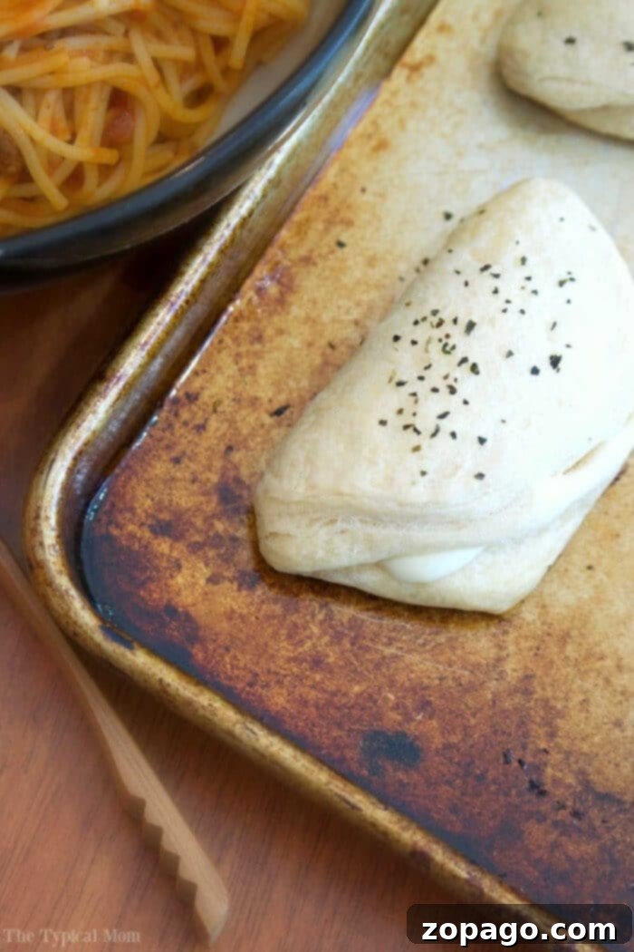 Easy cheese biscuit recipe using string cheese and refrigerated biscuits at the store. Great side dish or after school snack for kids. #rolls #biscuits Golden brown cheesy garlic biscuits, fresh out of the oven, piled high and ready to serve.