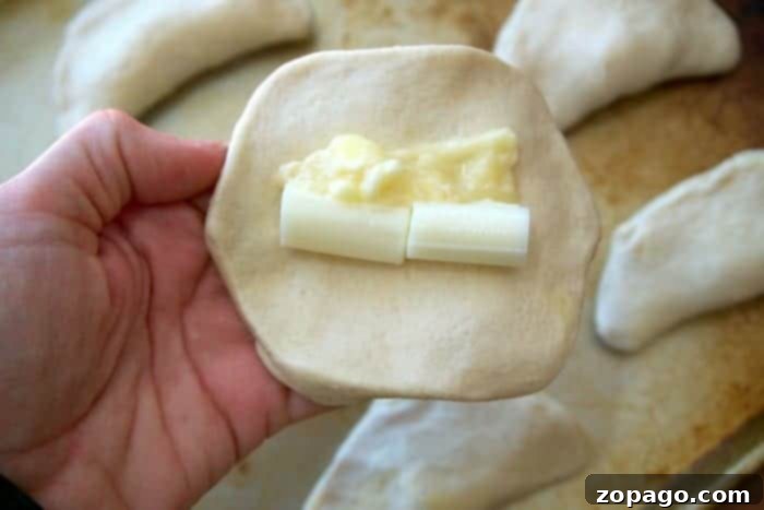 Easy Cheese-Stuffed Biscuits 4 Flattened refrigerated biscuit with cut string cheese and garlic butter filling.