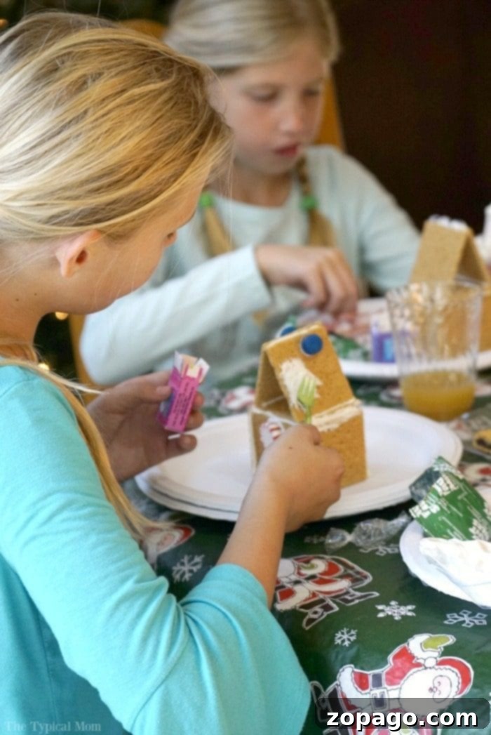 Kids enjoying a gingerbread house party, building their creations.