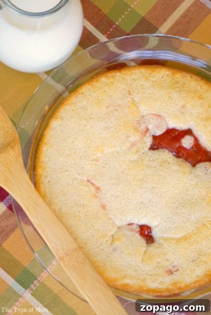 Easy Upside Down Cherry Pie: A delightful no-crust cherry pie filling dessert! A slice of golden-brown Upside Down Cherry Pie on a white plate, showcasing the rich red cherry filling at the bottom and the fluffy, cake-like top. A fork rests beside it, ready to enjoy.