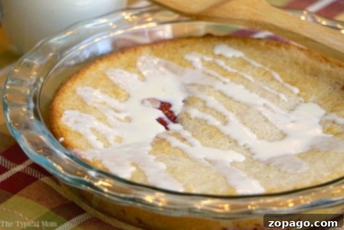 Easy Upside Down Cherry Pie: A Simple, Delicious No-Crust Dessert A slice of upside down cherry pie, revealing the luscious cherry layer at the bottom and a light, fluffy topping, on a white plate with a fork.