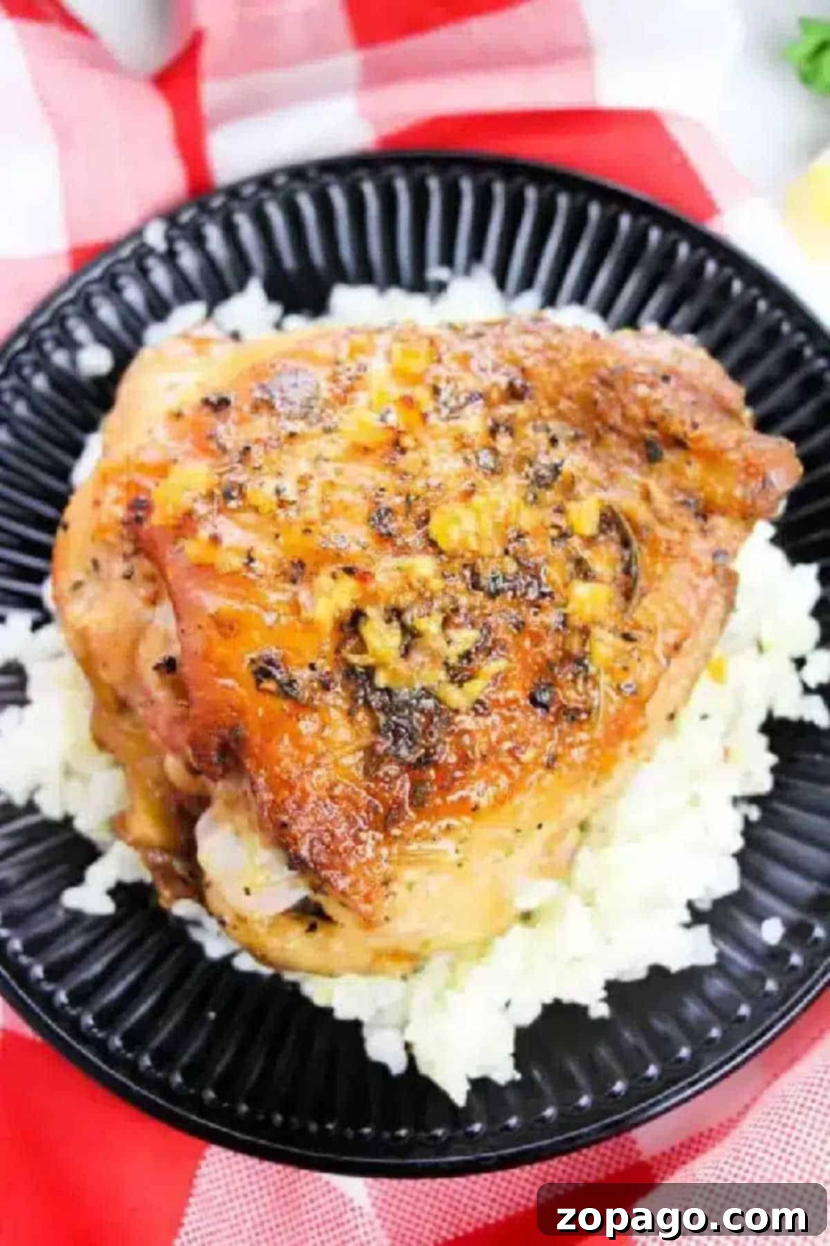 Baked bone in chicken thighs recipe that is made in one pot! So easy and done from start to finish in just 30 minutes with only 5 ingredients. Great healthy recipe. Roast chicken thigh with herbs served on a bed of white rice on a black plate—perfect inspiration if you’re wondering how long to bake bone-in chicken thighs at 350 for tender, flavorful results.