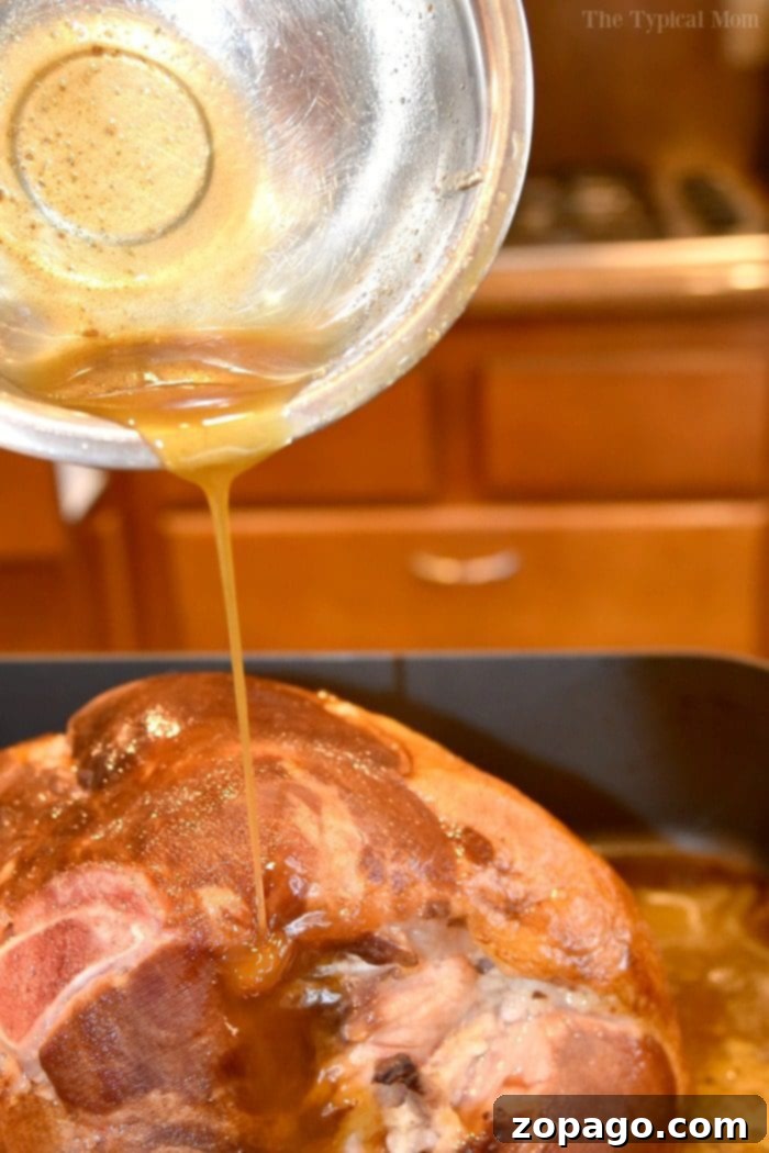 Baked ham glaze recipe with orange juice, brown sugar, and honey is incredibly simple and makes your ham taste amazing!! Just 3 ingredients, you've got to try this ham glaze next time. #ham #glaze #orangejuice #baked #holidays Delicious baked ham coated in a glistening orange juice and brown sugar glaze, ready for serving.