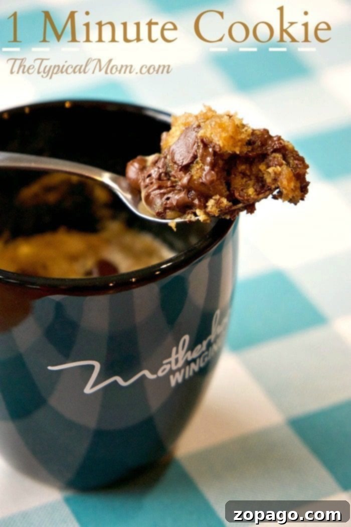 This chocolate chip cookie in a mug takes just one minute to cook perfectly in the microwave. It's the best easy, single-serving dessert for your sweet tooth. No sharing needed! ;) #chocolatechip #chocolate #cookie #mug #dessert #microwave #one #minute #easy #best A delicious chocolate chip cookie in a mug, perfectly baked and ready to be enjoyed.
