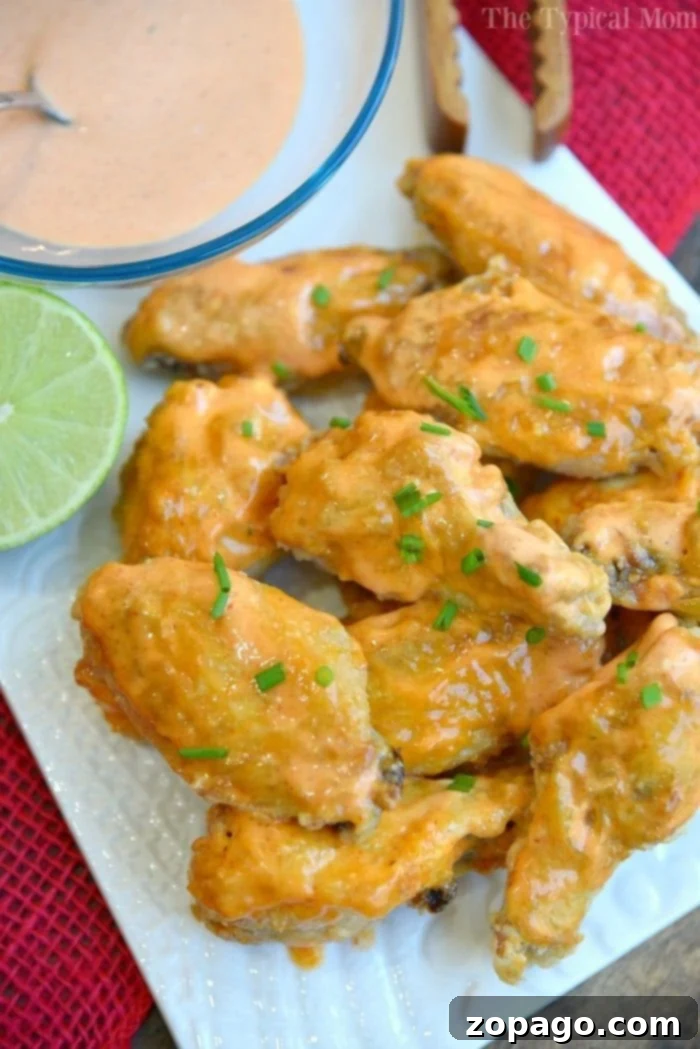 This is the best way to make a batch of sweet Sriracha baked chicken wings! The perfect appetizer or meal that's easy to make. These baked chicken wings are crispy and moist using this trick and the sauce is amazing with just the right sweet and heat you want. #chicken #wings #baked #sriracha #spicy #hot #sweet #crispy Sweet Sriracha Baked Chicken Wings