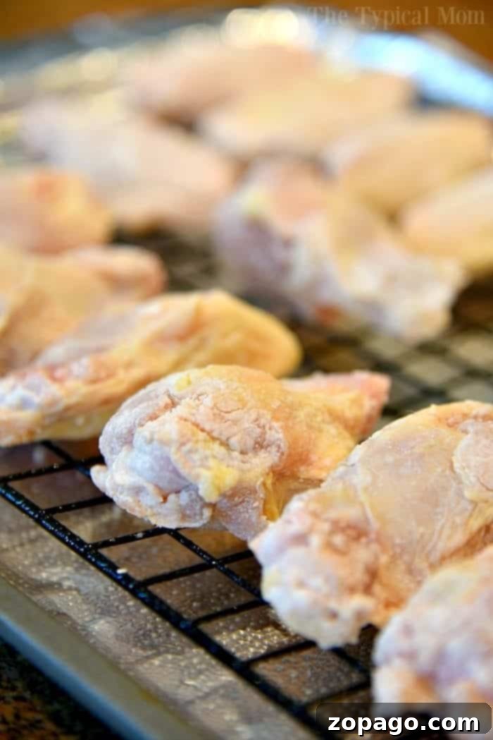This is the best way to make a batch of sweet Sriracha baked chicken wings! The perfect appetizer or meal that's easy to make. These baked chicken wings are crispy and moist using this trick and the sauce is amazing with just the right sweet and heat you want. #chicken #wings #baked #sriracha #spicy #hot #sweet #crispy Sriracha Chicken Wings