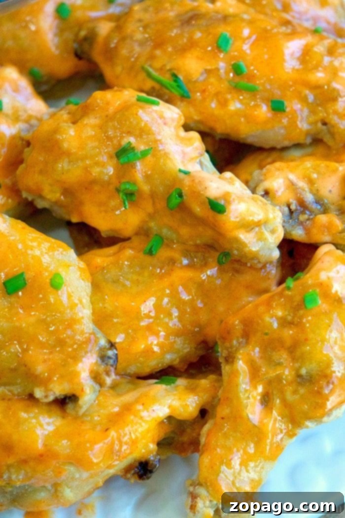 This is the best way to make a batch of sweet Sriracha baked chicken wings! The perfect appetizer or meal that's easy to make. These baked chicken wings are crispy and moist using this trick and the sauce is amazing with just the right sweet and heat you want. #chicken #wings #baked #sriracha #spicy #hot #sweet #crispy sweet sriracha sauce