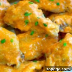 Close-up of glazed sriracha chicken wings garnished with chopped chives.