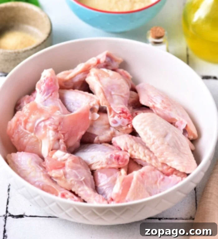 Unlock Crispy Baked Wings at 425 2 Raw chicken wings and ingredients laid out for preparation, focusing on how to bake crispy chicken wings.