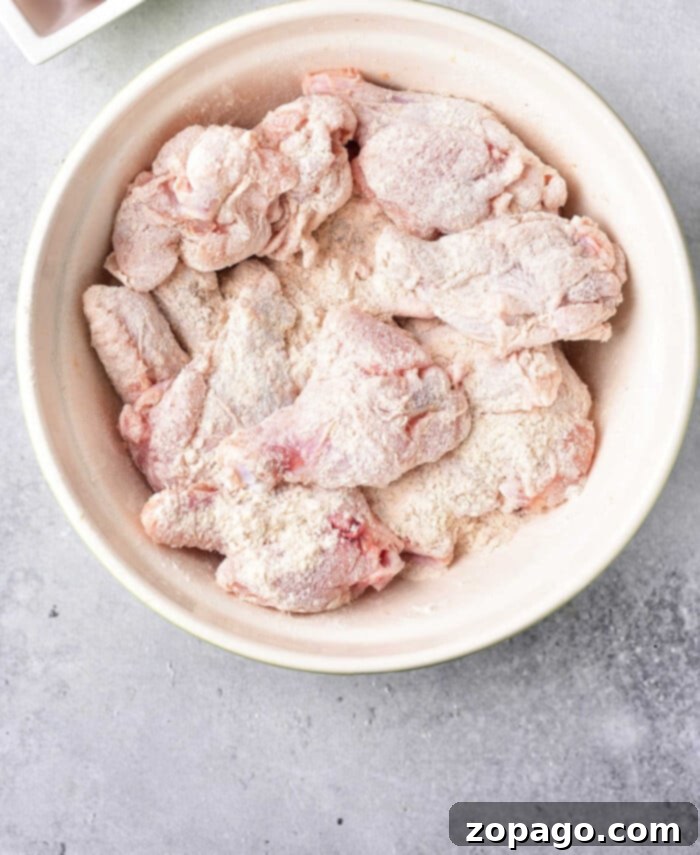 Ultimate Crispy Chicken Wings: Baking Perfection at 425 4 Raw chicken wings perfectly coated in baking powder and salt, nestled in a white bowl, poised for their transformation into crispy baked perfection.