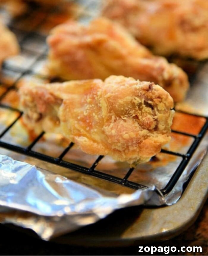 Ultimate Crispy Chicken Wings: Baking Perfection at 425 7 Irresistible, crispy chicken wings baked to perfection on a cooling rack with foil, emphasizing the simplicity and effectiveness of this baking method.