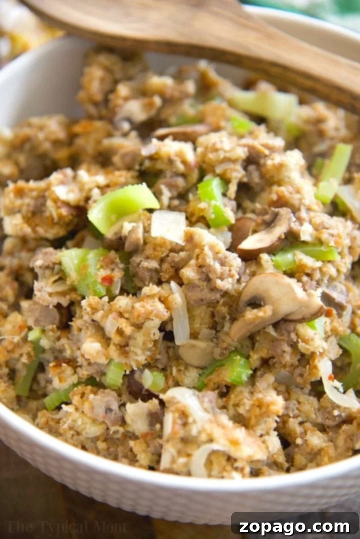 This Pickford stuffing is the MOST amazing stuffing recipe you will ever make! It's so good we make it at Thanksgiving, Easter, and year round! Super easy. A large serving bowl filled with golden-brown Pickford stuffing, showcasing its rich texture with visible bread cubes, tender mushrooms, and fragrant herbs. The title emphasizes its status as the most amazing stuffing recipe.
