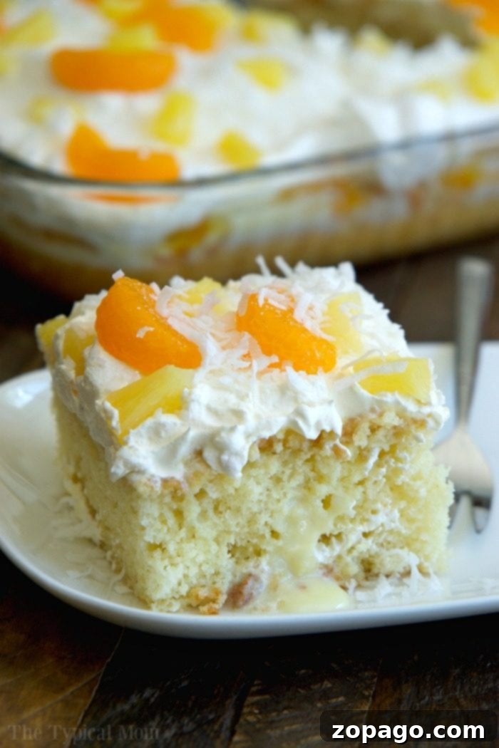 Easy Tropical Poke Cake: A Summer Delight Fully decorated tropical poke cake with fresh fruit and toasted coconut.