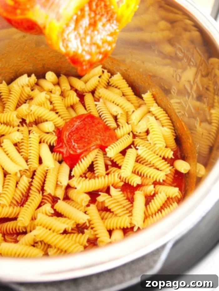 Pressure cooker pizza pasta is a fantastic weeknight meal. It's incredibly easy to dump all ingredients and favorite pizza toppings into your pressure cooker for a quick, delicious dinner. A vibrant bowl of Instant Pot Pizza Pasta, highlighting the ease and deliciousness of pressure cooker recipes, garnished with fresh basil.