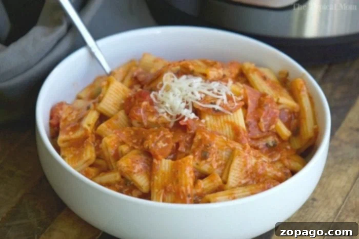 Instant Pot pizza pasta is a fantastic, easy, and satisfying family dinner. Enjoy the convenience of a pressure cooker for this delicious pizza-inspired pasta meal that tastes even better the next day! #InstantPot #PizzaPasta #DinnerIdeas #TheTypicalMom A serving of Instant Pot pizza pasta garnished with fresh herbs, ready to be enjoyed.