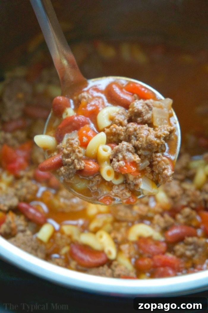 Instant Pot chili mac recipe that takes 5 minutes to cook and you and your kids will love! A classic old fashioned goulash dinner packed with flavor. #instantpot #chilimac #chili #macaroni #goulash #pressurecooker #groundbeef #instantpotrecipes #thetypicalmom #ninjafoodi #ninjafoodirecipes #crockpotexpressrecipes Instant Pot Chili Macaroni Recipe with ground beef and beans, topped with melted cheese.