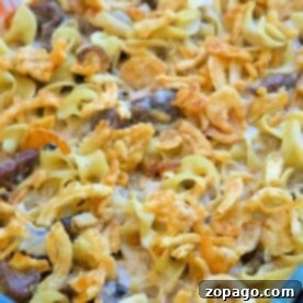 An easy beef stroganoff casserole recipe, featuring a baked dish with creamy sauce, tender noodles, and crispy onions, all beautifully presented in a glass dish.