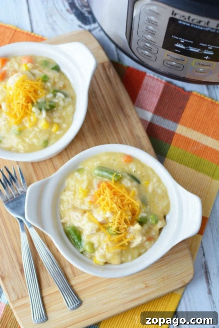 Instant Pot chicken and rice casserole recipe: a quick, creamy, and flavorful family dinner with perfectly cooked chicken, rice, and hidden vegetables. Two white bowls of creamy and tender pieces of pressure cooker chicken and rice sit on a wooden board near an Instant Pot.