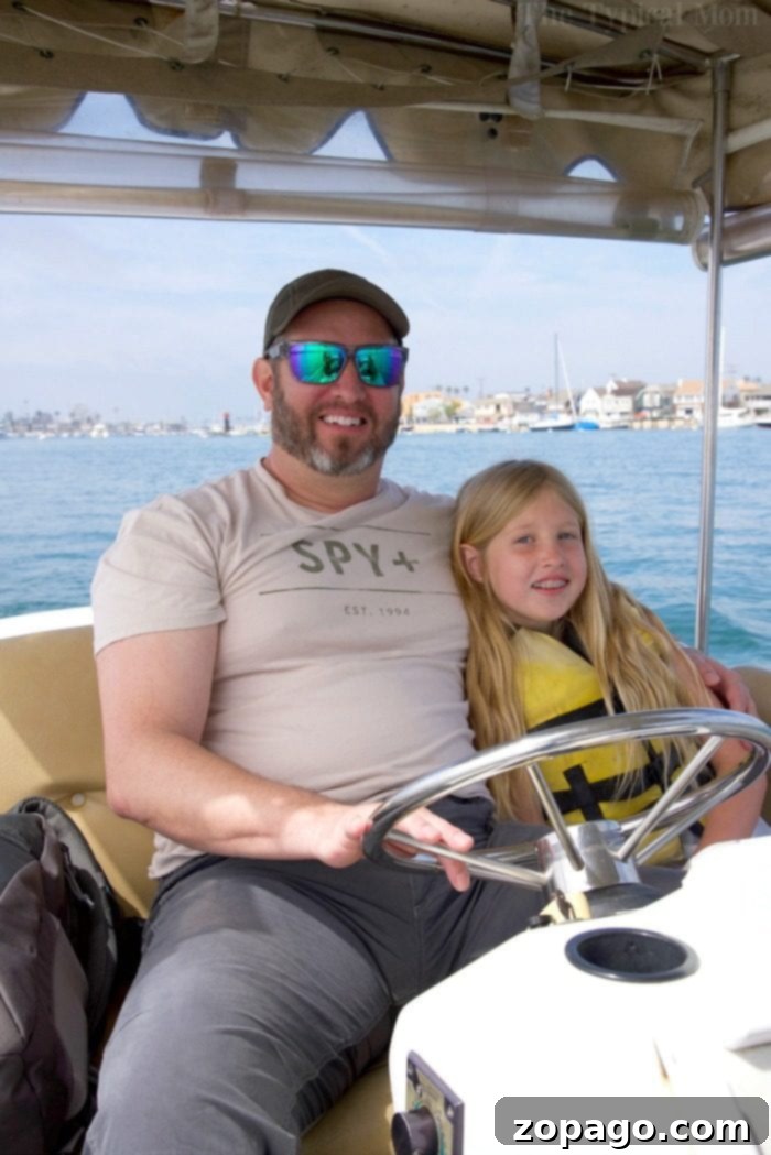 Newport Beach Boat Rentals: An Unforgettable Way to Explore Balboa Island and the Coastline A family enjoying a charming electric boat rental in Newport Beach with coastal homes in the background