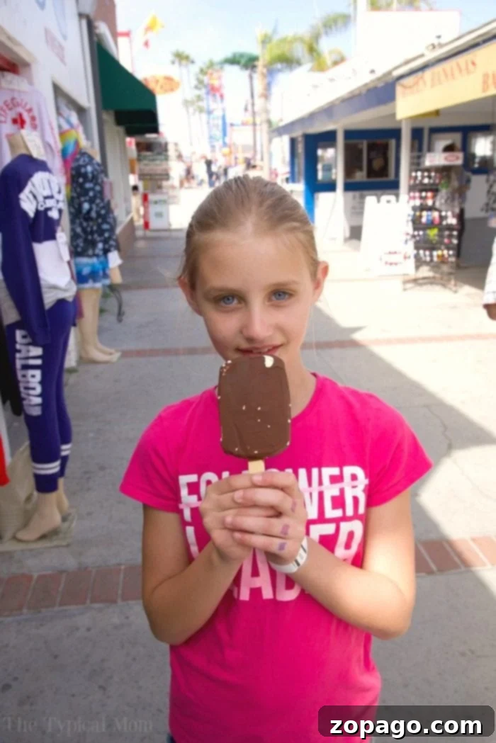 Balboa Fun Zone in Newport Beach is a fun place for families. There's the Balboa pier, beach, ride the ferry, and you can rent a boat too. #california #balboaisland #balboafunzone Family enjoying treats at Balboa Fun Zone with the bay in the background