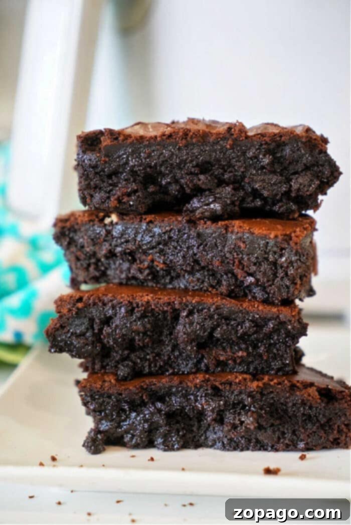 Make brownies out of cake mix easily with just 2 ingredients and any flavor of cake mix you like! Rich and chewy strawberry brownies are our favorite but try lemon cake mix brownies too. A quick dessert your kids will love and cheap to make for a bunch of people #cakemix #brownies #strawberry #lemon #cakemixbrownies Fudgy strawberry cake mix brownies on a cooling rack, showcasing a simple dessert made from a box of cake mix.