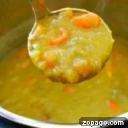 Ladle scooping steaming Instant Pot split pea soup with carrots from a pot.