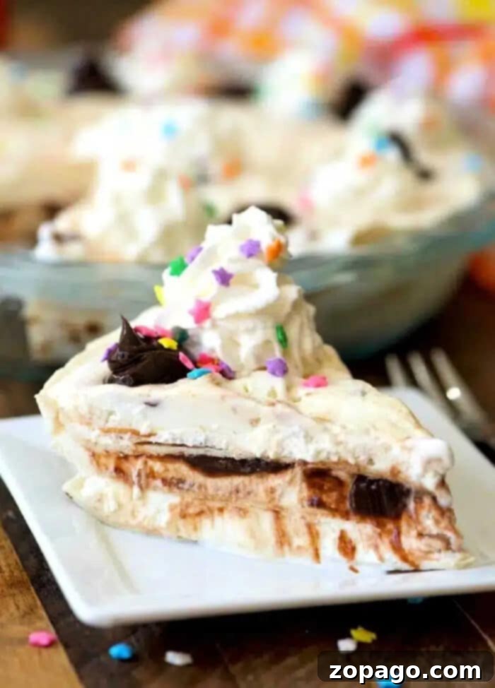This easy layered ice cream sundae pie is incredible! Layers of fudge and ice cream topped with whipped cream and sprinkles makes it a fun birthday dessert. Delicious and easy layered ice cream sundae pie with hot fudge, whipped cream, and sprinkles.
