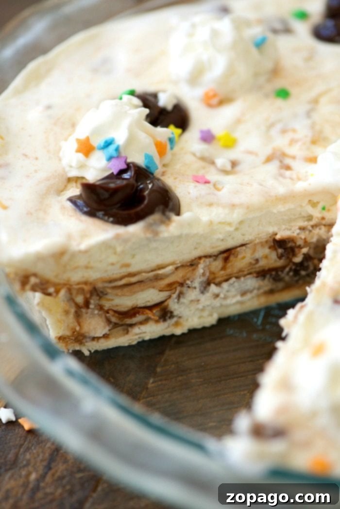 Decadent Sundae Pie 5 Close-up of the easy ice cream sundae pie layers before freezing, showing the tortilla, ice cream, and fudge.