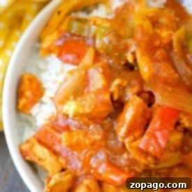 A bowl of chicken cacciatore with bell peppers and onions over white rice, reminiscent of an instant pot chicken cacciatore recipe, sits next to a yellow polka dot cloth.