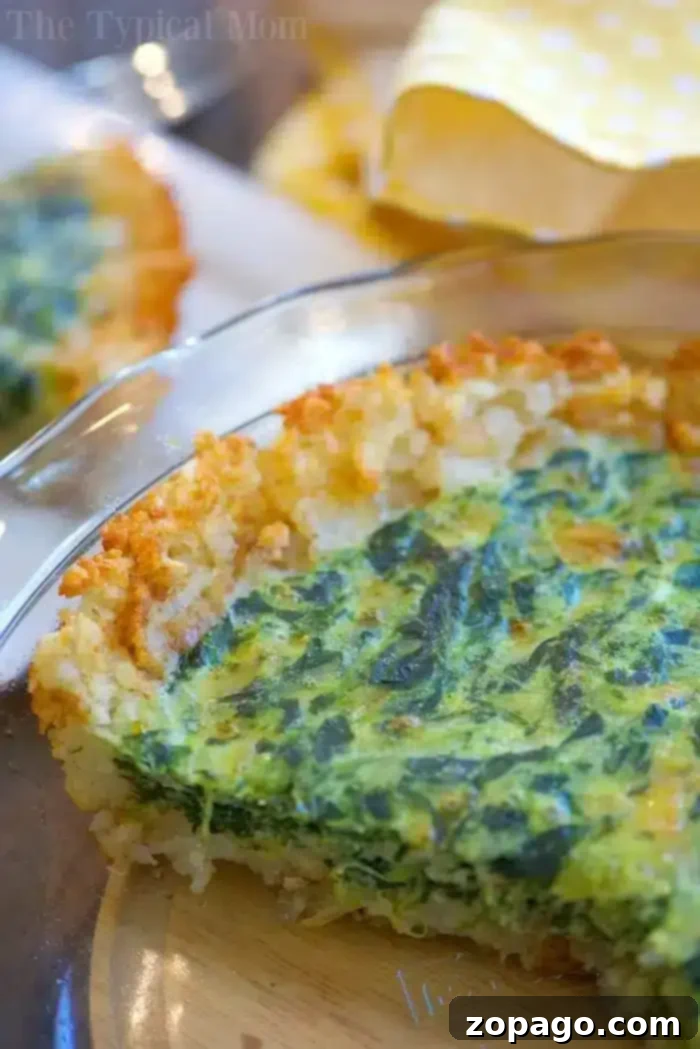 Tater Tot Crusted Spinach Quiche: A perfect breakfast or brunch with a crunchy tater tot pie crust and warm egg filling. Golden brown tater tot pie crust formed in a glass pie dish, ready for filling
