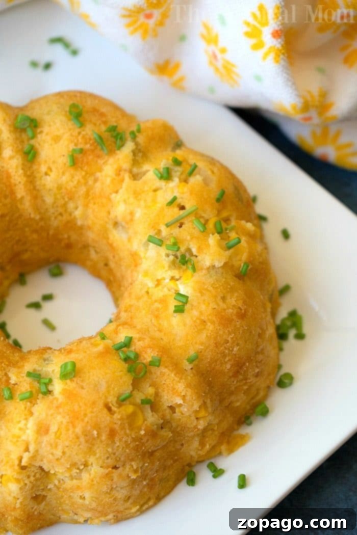 Creamy Cheesy Instant Pot Corn Casserole with Chives A generously sized portion of cheesy corn casserole, beautifully garnished with fresh chives, rests invitingly on a pristine white plate, mirroring the deliciousness of a perfectly made Instant Pot corn casserole.