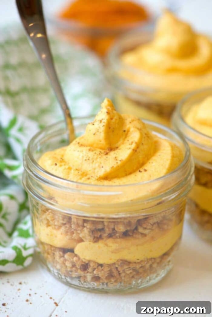 Easy No Bake Pumpkin Cheesecake in Mason Jars – A perfect Fall or year-round dessert! Delicious no-bake pumpkin cheesecake served in a mason jar, garnished with a swirl of cream and a sprinkle of cinnamon, perfect for fall.