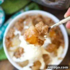 A spoonful of apple crisp with ice cream, featuring an Instant Pot in the background, symbolizing an easy dump cake creation.