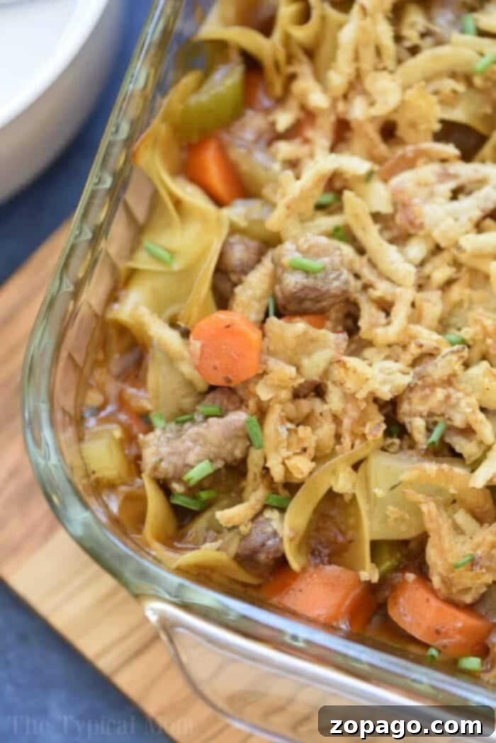 Hearty Beef Stew Casserole with Vegetables and Crispy Fried Onions. Easy beef stew casserole with carrots, celery, and crispy fried onions in a glass baking dish, fresh out of the oven.