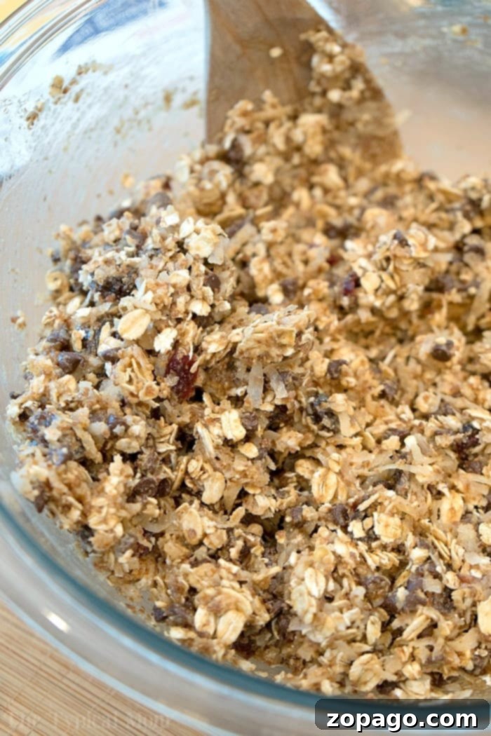 Effortless Chewy Homemade Granola Bars 3 A tray of freshly made homemade granola bars, cut into squares, with a few stacked ready to be eaten