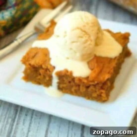 A slice of pumpkin pudding cake recipe is topped with a scoop of melting vanilla ice cream on a white plate.