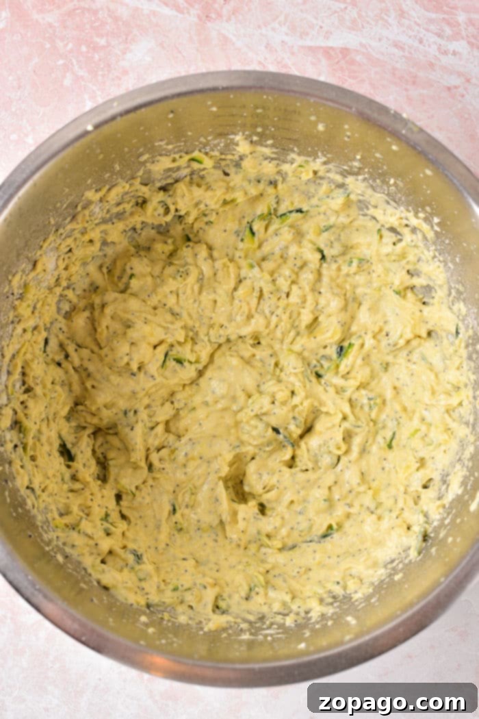 Zesty Lemon Poppy Seed Bundt Cake 2 A vibrant mixing bowl holds a creamy lemon poppy seed cake batter, ready for the Instant Pot, embodying the joy of homemade baking.