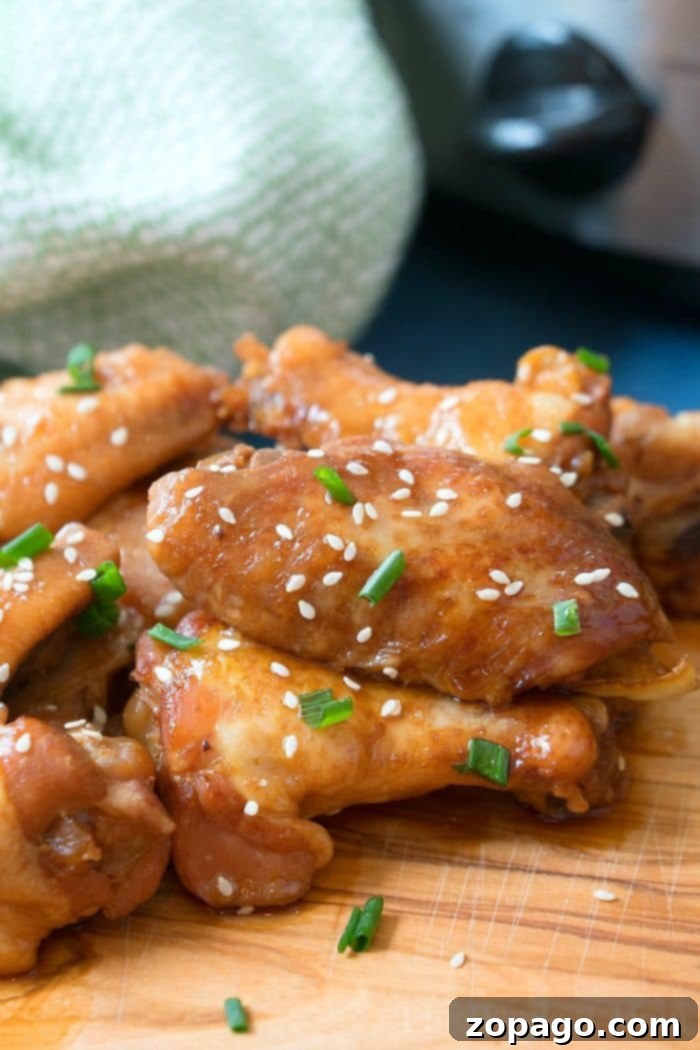 Sticky Teriyaki Chicken Wings 2 Slow cooker teriyaki chicken wings, glistening with a spicy and sweet sauce, garnished with sesame seeds and green onions