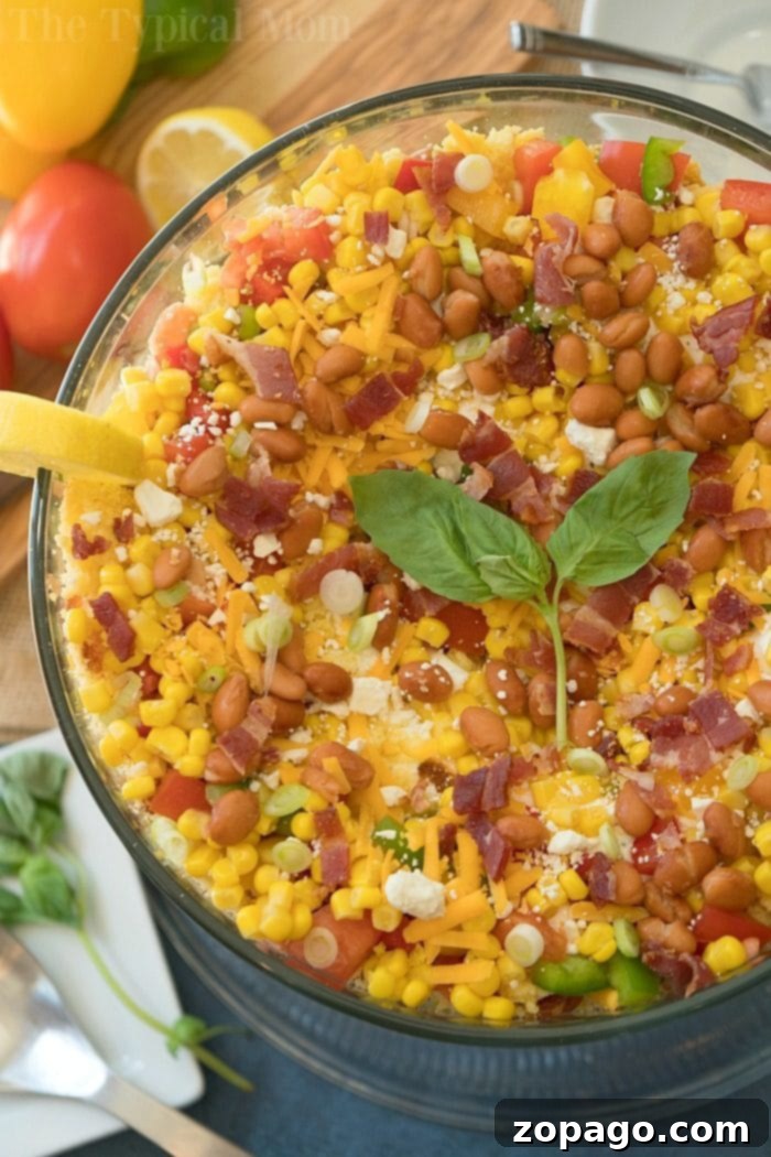 Layered cornbread salad is a perfect side dish during the holidays or a barbecue! Layers of corn, cheese and more make it irresistible! #corn #salad #layered #cornbread #sidedish easy layered cornbread salad