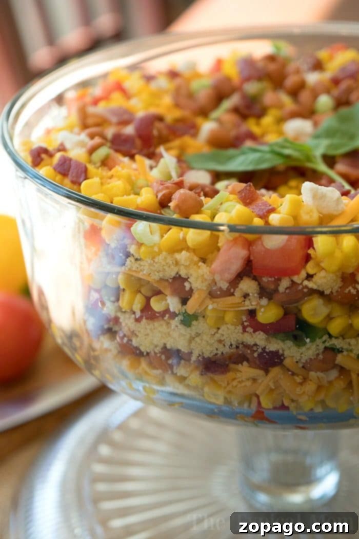 This easy layered cornbread salad recipe is a perfect side dish during the holidays or a barbecue! Layers of corn, cheese and more make it irresistible! #corn #salad #layered #cornbread #sidedish Jiffy Layered Cornbread Salad